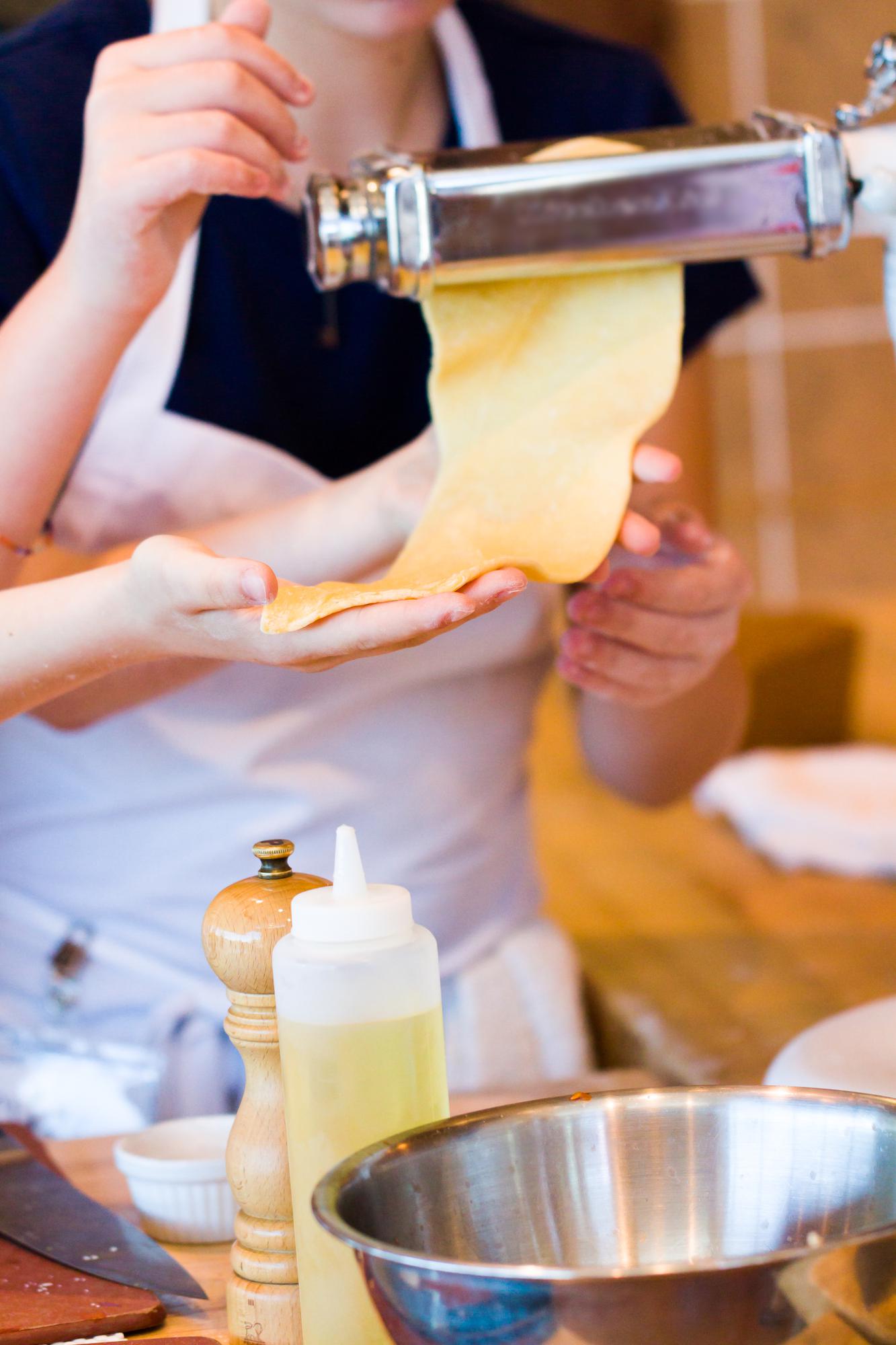 Chef shaping handmade pasta in warm kitchen