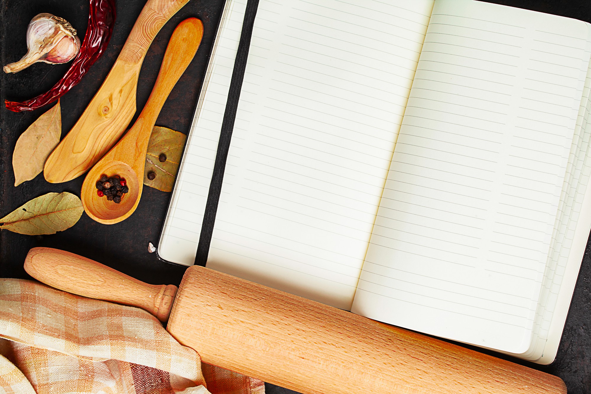 Stack of recipe notebooks and tasting spoons